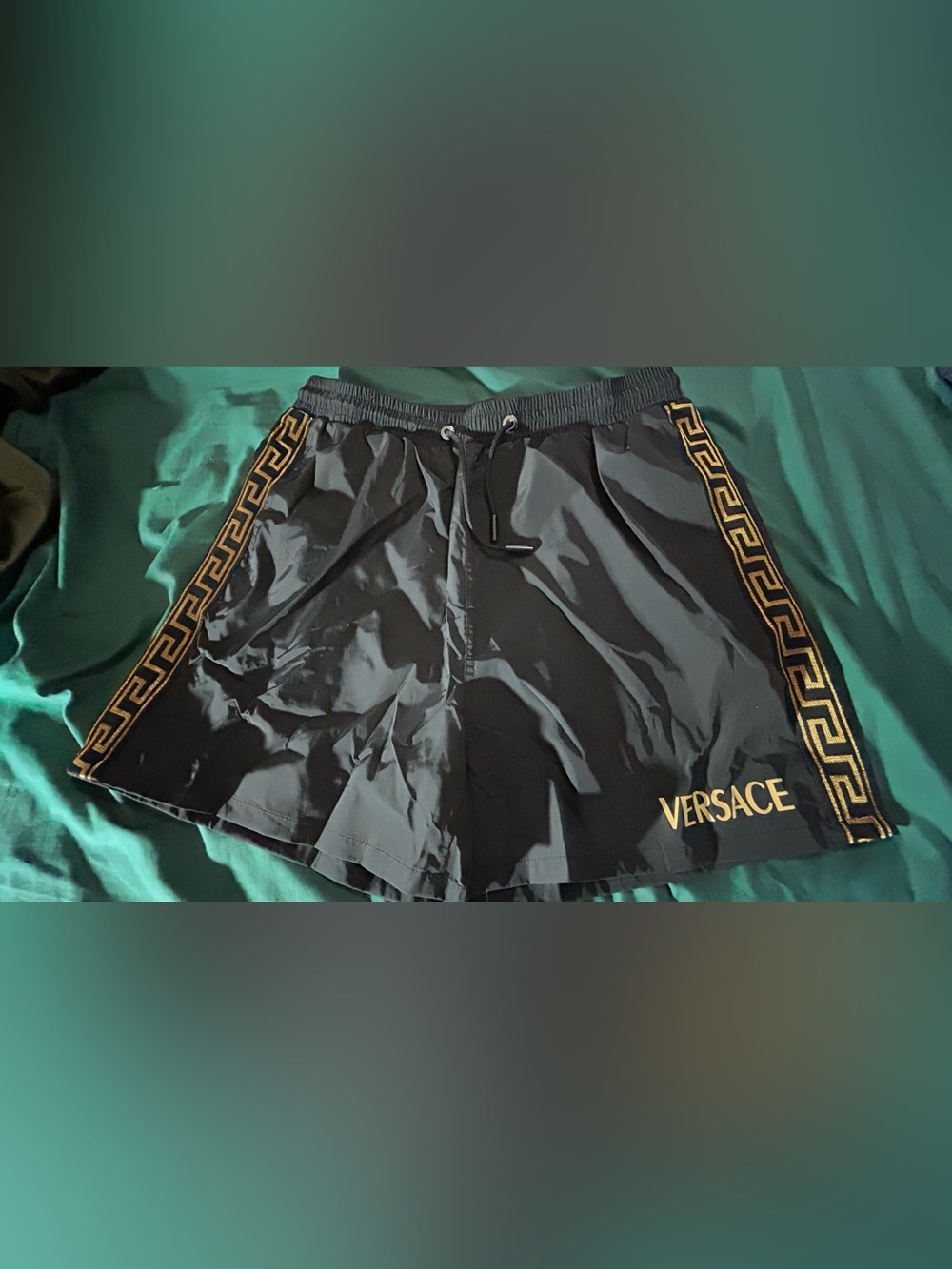 Versace Black swim trunks with gold trim, and gold lettering